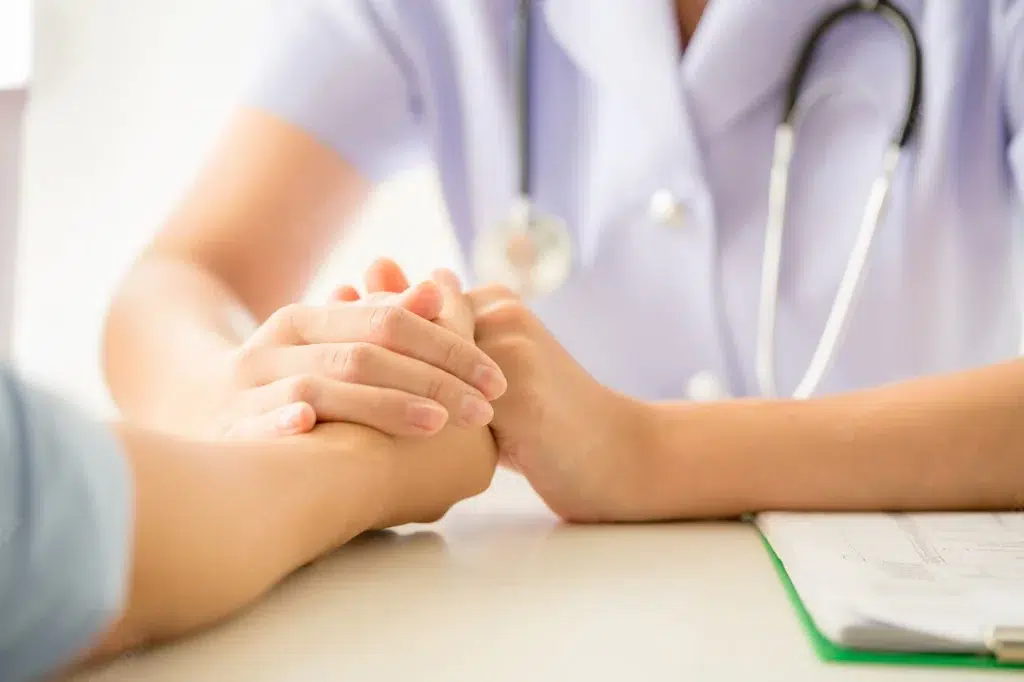 doctor and patient holding hands