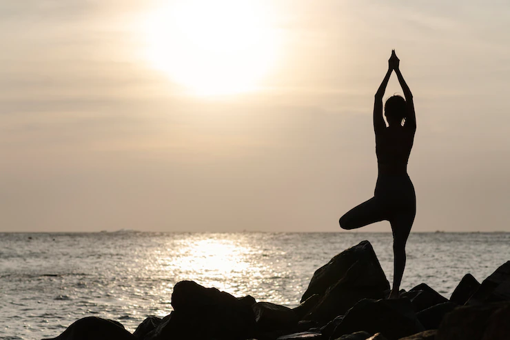 full-shot-woman-doing-yoga-sunset_23-2149358956