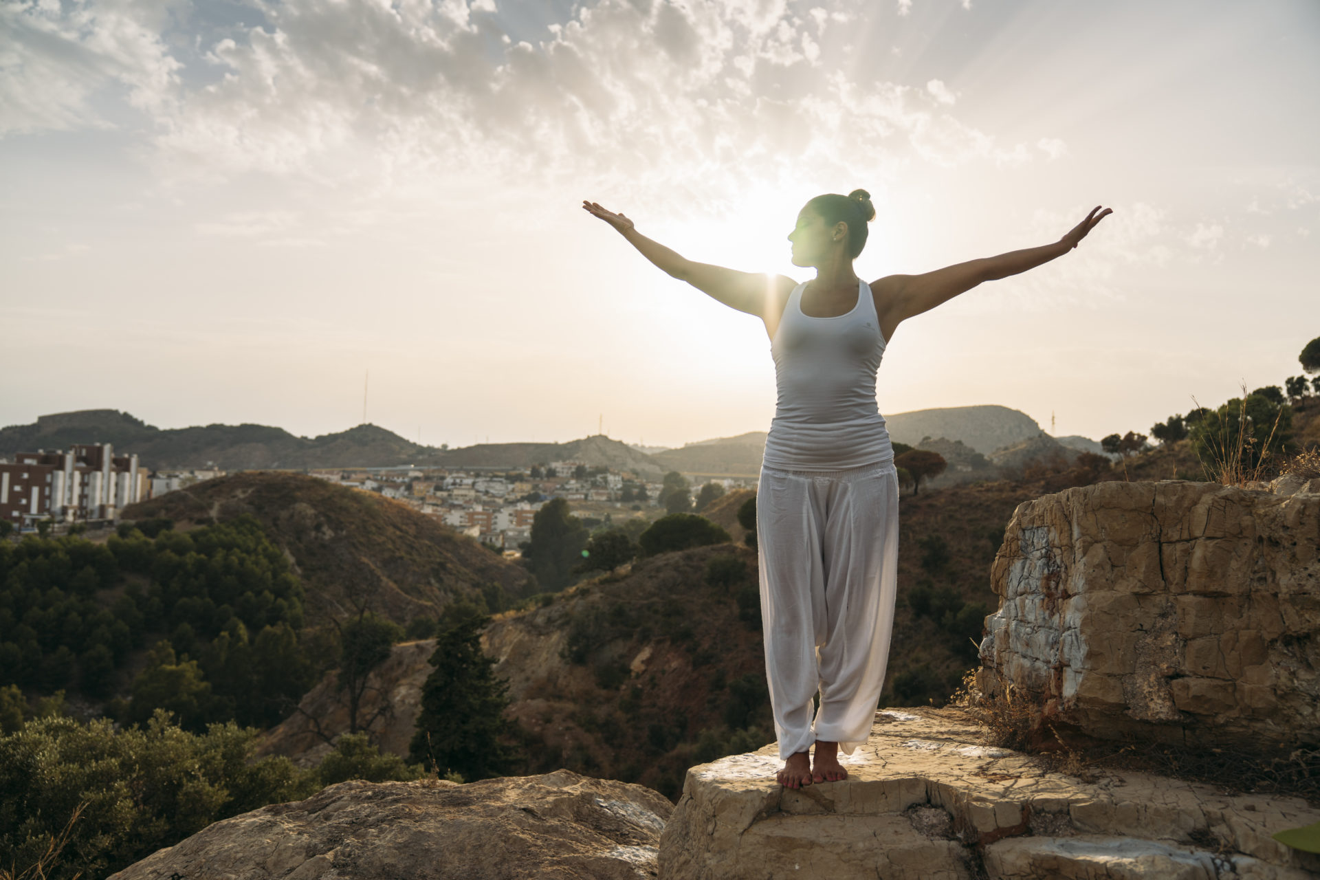 woman standing on landscape with arms open