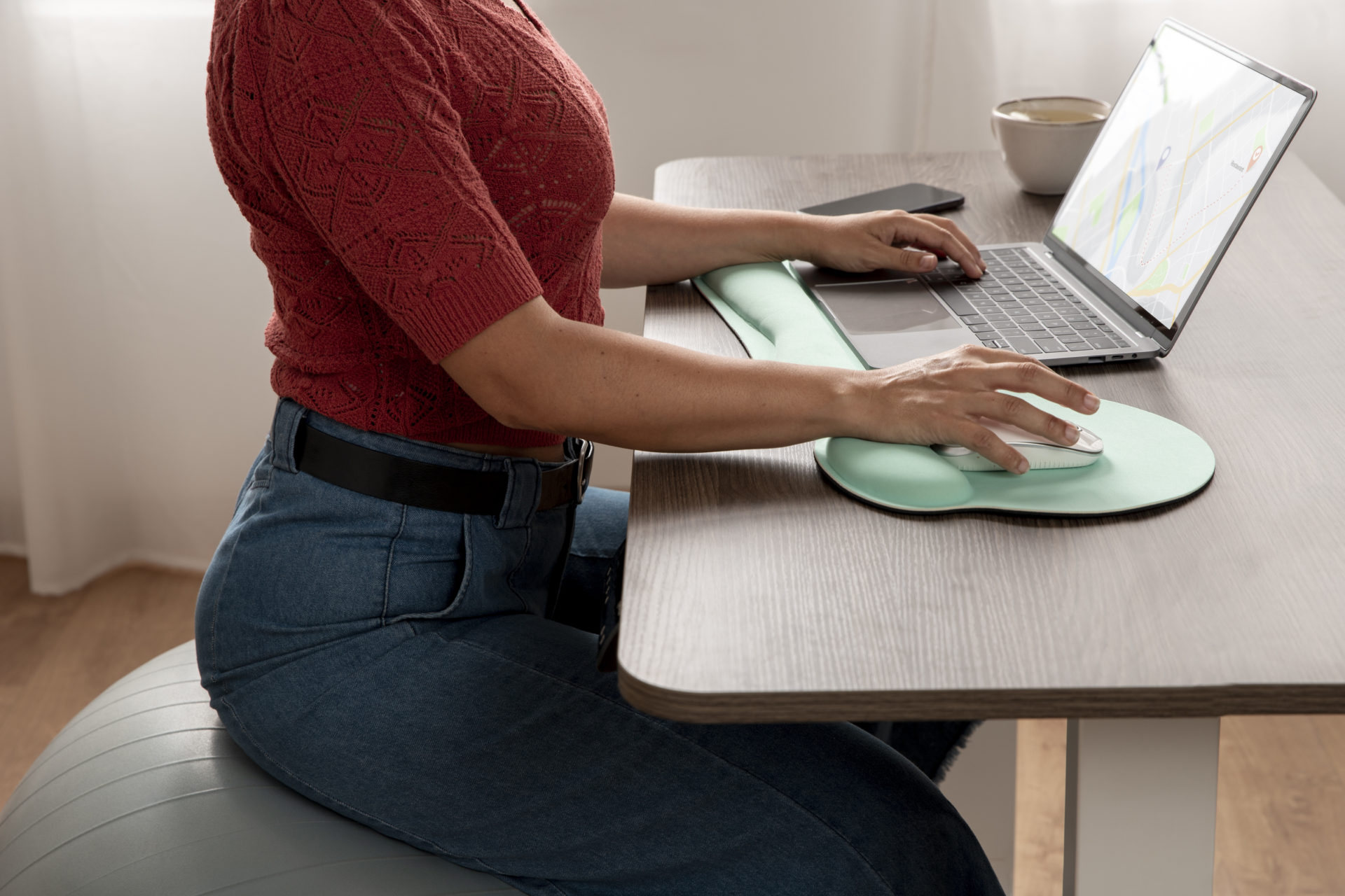 woman sitting on yoga ball in front of laptop